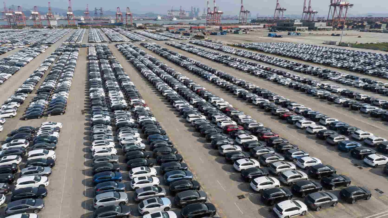Rows of new and used export-ready cars parked at a Guangzhou vehicle yard near Nansha Port
