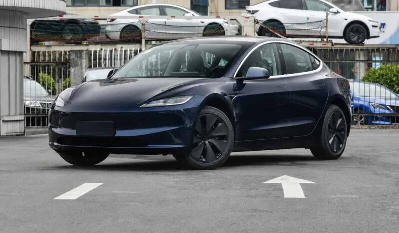 Front three-quarter view of Tesla Model 3 2025 facelift rear-wheel drive blue electric sedan showing streamlined body, LED headlights, black wheels and exterior side profile