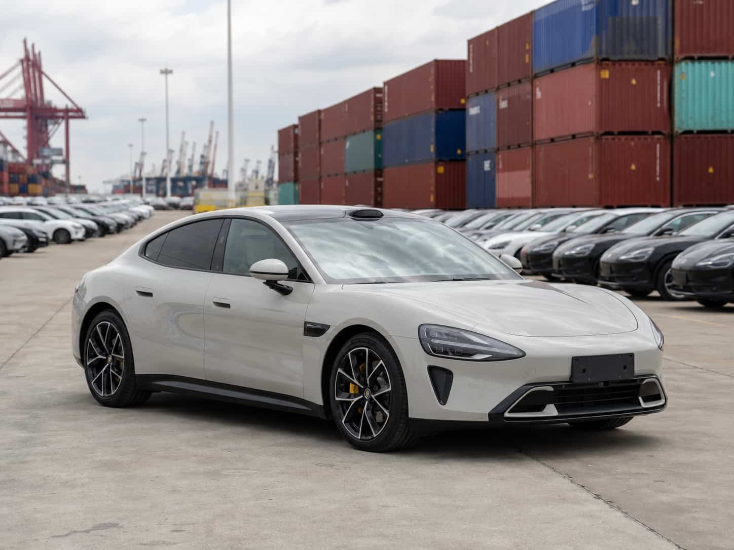 Xiaomi SU7 electric sports sedan at a Guangzhou vehicle export yard ready for container loading to overseas dealers