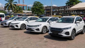 Row of Chinese sedans and compact SUVs used as taxis in an African city including BYD and Changan models for transport business operators